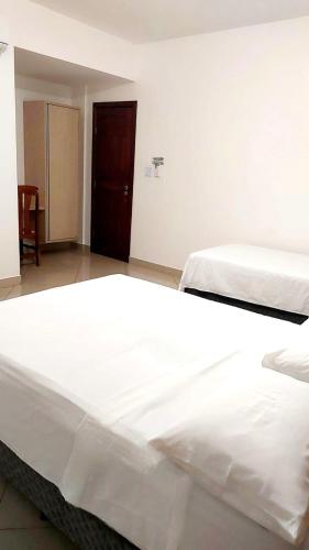 a large white bed in a room at Brisas do Mar HOTEL & APART in Valença