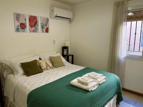 1 dormitorio con 1 cama con toallas en Mendoza C&D en Godoy Cruz