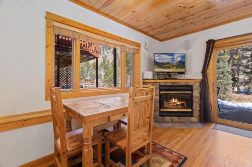 a dining room with a table and a fireplace at Bugle Pointe B14 by Estes Park Condos in Estes Park