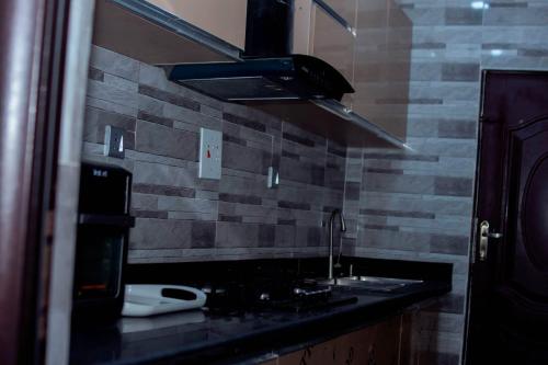 a kitchen with a sink and a stove at Feyintola Shortlet Apartment in Ondo