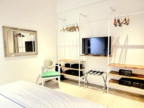 Habitación blanca con TV y silla en Ocean view luxury apartments, en Negombo