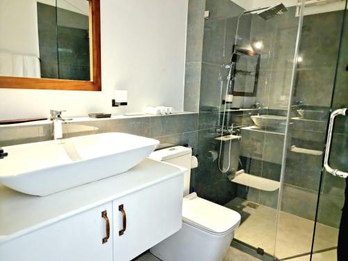 y baño con lavabo, aseo y ducha. en Ocean view luxury apartments, en Negombo