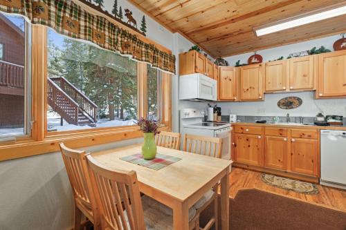 a kitchen with a wooden table with chairs and a window at Bugle Pointe B18 by Estes Park Condos in Estes Park