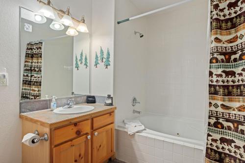 a bathroom with a sink and a bath tub at Bugle Pointe B18 by Estes Park Condos in Estes Park
