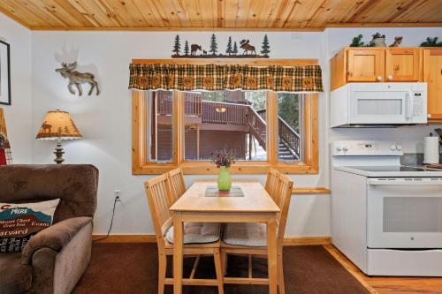 a living room with a table and a kitchen at Bugle Pointe B18 by Estes Park Condos in Estes Park