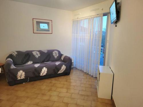 un salon avec un canapé et une télévision à écran plat dans l'établissement Studio - Résidence avec piscine, au Cap d'Agde