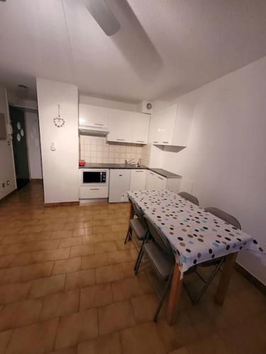 une cuisine avec une table et des chaises dans une pièce dans l'établissement Studio - Résidence avec piscine, au Cap d'Agde