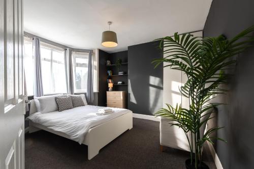 una camera con letto e pianta in vaso di 4 bedrooms house for working Professionals a Southampton