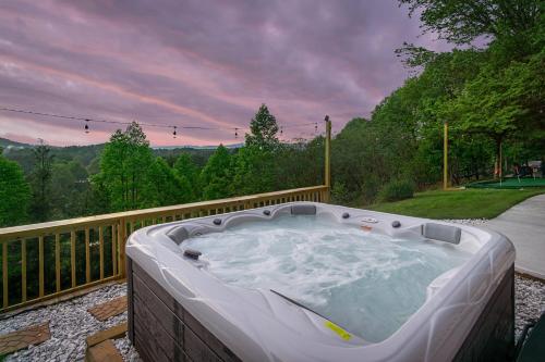 a large hot tub on a deck with a view at Massive Asheville Compound A Memorable Experience in Weaverville