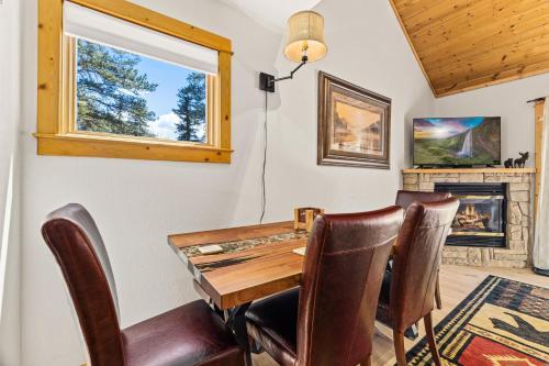 une salle à manger avec une table et des chaises et une cheminée dans l'établissement Creekside Condos H by Estes Park Condos, à Estes Park