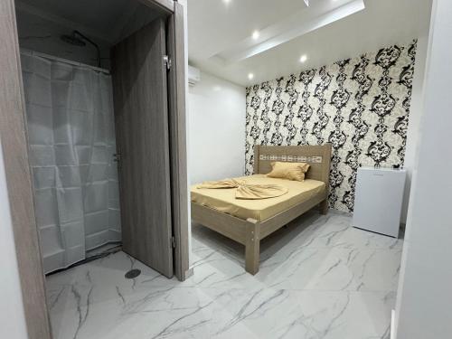 małą sypialnię z łóżkiem i prysznicem w obiekcie Pereira Lounge Bar w mieście Praia
