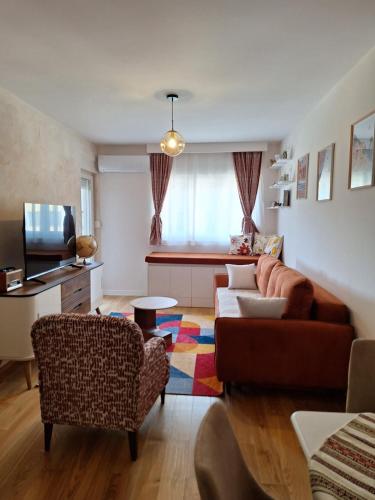 a living room with a couch and a tv at Geppetto Apartment in Podgorica