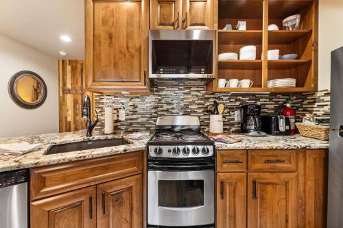 Una cocina con gabinetes de madera y un horno de estufa. en Creekside Suites 03 by Estes Park Condos, en Estes Park