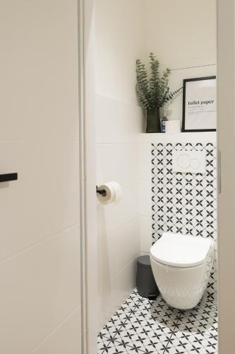 a bathroom with a toilet and a black and white tile floor at Moderní byt s přímým vstupem do parku v centru Ostravy in Jáma Jindřich