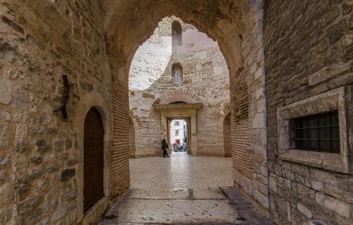 a person walking through an alley in a castle at Apartment Near Bacvice in Split