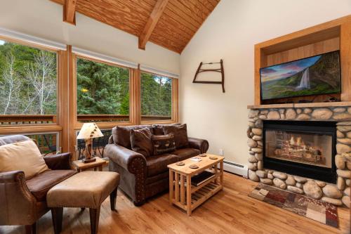 a living room with a fireplace and leather furniture at Creekside Suites 05 by Estes Park Condos in Estes Park
