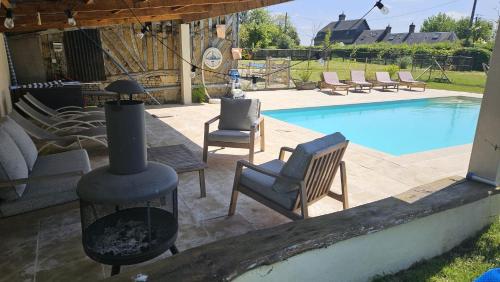 einen Hinterhof mit einem Kamin neben einem Pool in der Unterkunft Maison de charme - Piscine chauffée - 8 personnes in Danestal