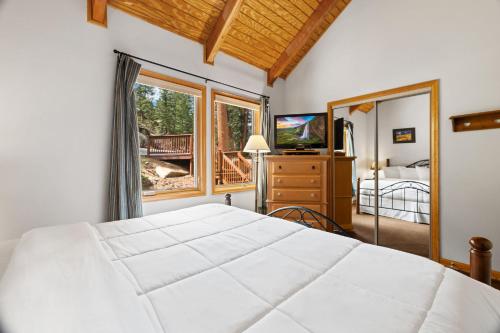 a bedroom with a large white bed and a balcony at Creekside Suites 10 by Estes Park Condos in Estes Park
