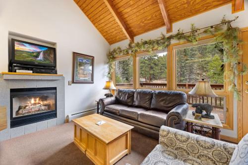 a living room with a couch and a fireplace at Creekside Suites 10 by Estes Park Condos in Estes Park