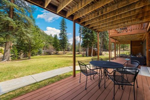 a patio with a table and chairs on a deck at Creekside Suites 17 by Estes Park Condos in Estes Park