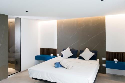 a bedroom with a large white bed with blue accents at Aschitelli luxury retreat in Polignano a Mare