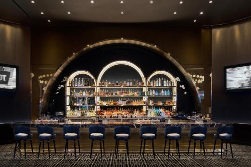 a bar with blue stools in front of a large wall at Fontainebleau Las Vegas in Las Vegas
