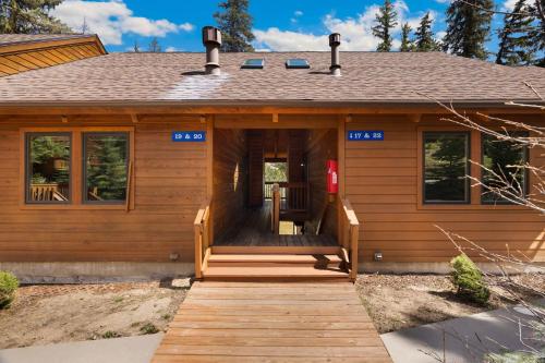 a log cabin with a wooden walkway leading to the front door at Creekside Suites 19 by Estes Park Condos in Estes Park