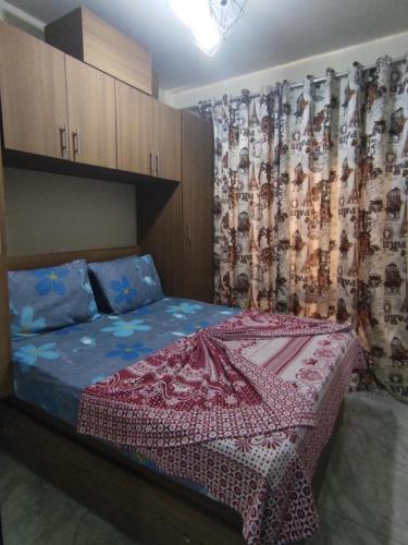 1 dormitorio con 1 cama con cortina estampada en BTM RENTAL CHALETS PORTO MATROUH FAMiLY ONLY, en Marsa Matruh