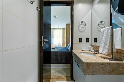 een badkamer met een wastafel en een spiegel bij The Sun Maravilhoso in Brasilia