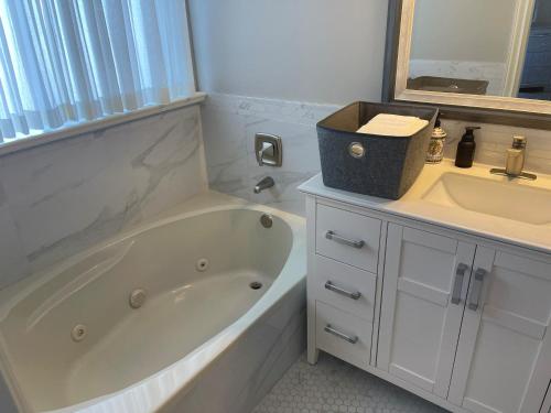 a bathroom with a bath tub and a sink at View of Ocean & MOUNT BAKER in White Rock