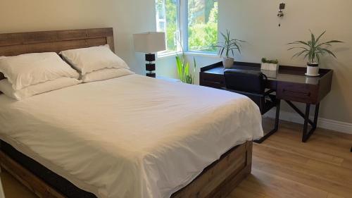 a bedroom with a bed and a desk and a window at View of Ocean & MOUNT BAKER in White Rock
