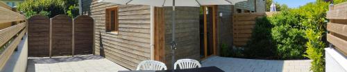 eine Terrasse mit Tisch, Stühlen und Sonnenschirm in der Unterkunft Acacia in Cherbonnières