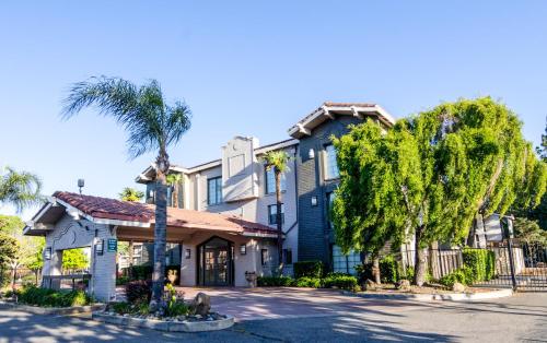 a house with a palm tree in front of it at La Quinta Inn by Wyndham Stockton in Stockton