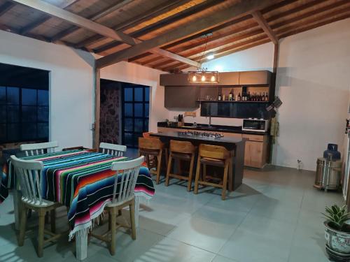 uma cozinha com uma mesa e algumas cadeiras e um balcão em cabaña la esmeralda em El Peñol