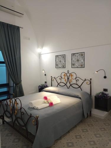a bedroom with a bed with two towels and flowers on it at Splendore del Sole in Polignano a Mare