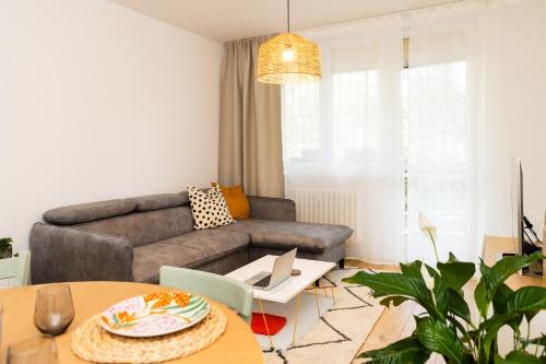 a living room with a couch and a table at Moderní byt s přímým vstupem do parku v centru Ostravy in Jáma Jindřich