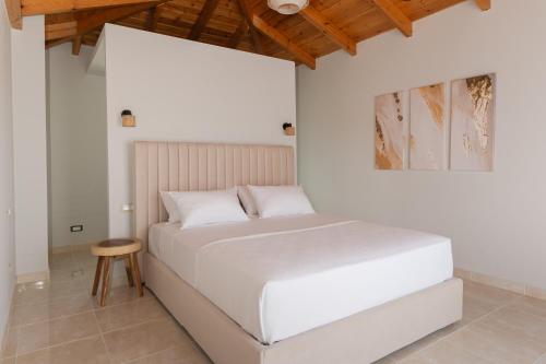a white bed in a room with a wooden ceiling at Vasilopoulos Residences - Villa Kalliste in Argostoli