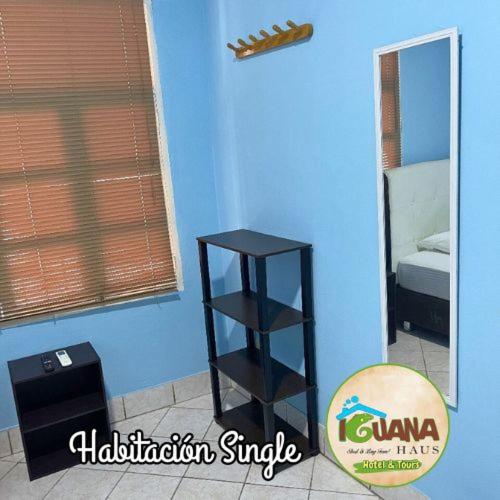 a black shelf in a room with a blue wall at IGUANA HAUS IQUITOS in Iquitos