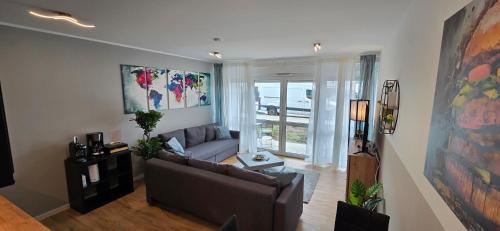 uma sala de estar com um sofá e uma grande janela em Design Luxus, Vollausstattung, Neubau, 30min Hbf Leipzig 8, Nähe Flughfaen, BMW, DHL, Amazon em Schkeuditz