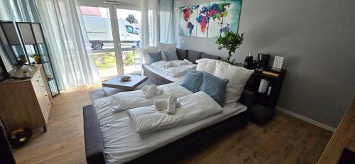 ein großes Sofa mit Kissen darauf im Wohnzimmer in der Unterkunft Design Luxus, Vollausstattung, Neubau, 30min Hbf Leipzig 8, Nähe Flughfaen, BMW, DHL, Amazon in Schkeuditz