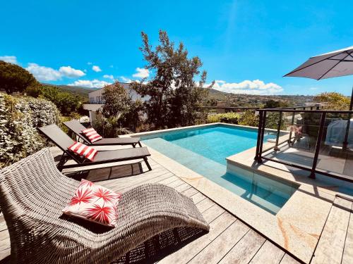 uma piscina com duas espreguiçadeiras e um guarda-sol em Villa Livia Porticcio piscine 500m plage em Porticcio