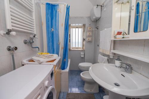 bagno bianco con lavandino e servizi igienici di Casa Maria Vittoria a Minori