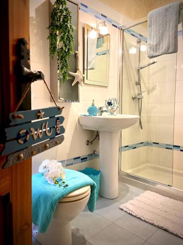 a bathroom with a toilet and a sink and a shower at Farmhouse Grazzja with pool in Qala