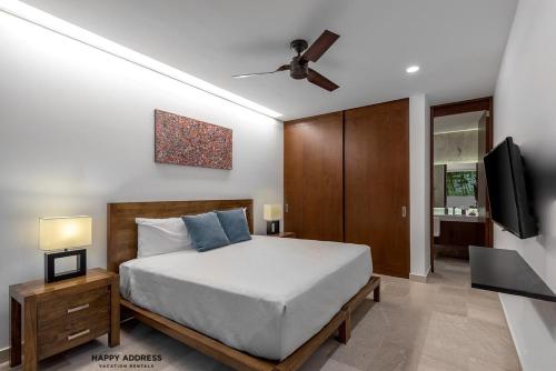 a bedroom with a bed and a flat screen tv at Trendy 1 BR apartment in Cruz Con Mar Brand New Building in Playa del Carmen