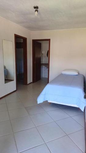 a bedroom with a bed and a tiled floor at Vinha dos Lagos Hotel in Rancho Queimado