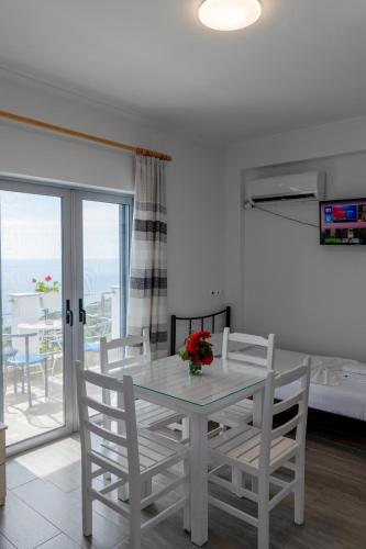 a white dining room with a table and chairs at Eduard Lagji Apartament in Lukovë