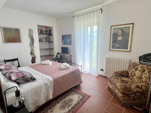 a bedroom with a bed and a chair and a window at Chez Vittoria in Greccio