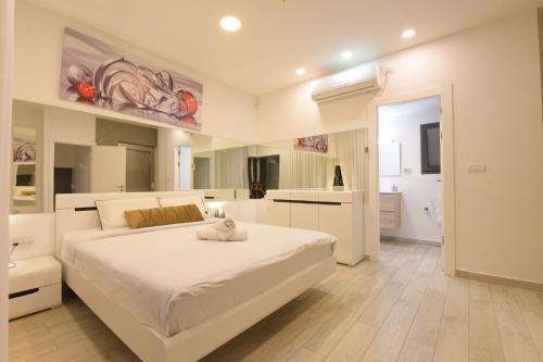 エイラットにあるNew ! 430m Luxury Best Top Class 8-Bdr Exclusive Villa Top Design HEATED Pool Jucuzzi Saunaの白いベッドルーム(大型ベッド1台、バスルーム付)