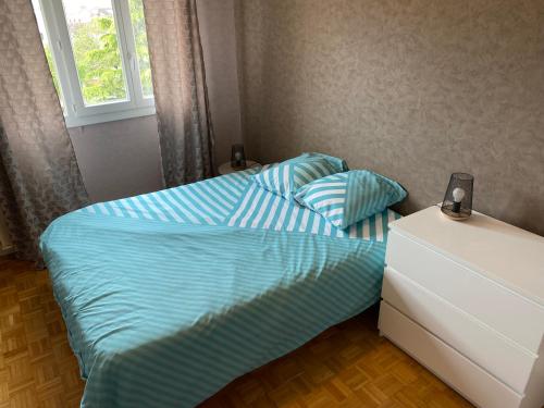 une petite chambre avec deux lits et une fenêtre dans l'établissement Bon séjour - Appartement 3 chambres, à Chalon-sur-Saône
