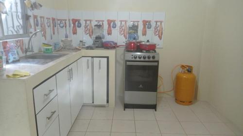 La cocina está equipada con fogones, fregadero y encimera. en CASA VACACIONAL URBANIZACIÓN PROGRESIVA en Manta